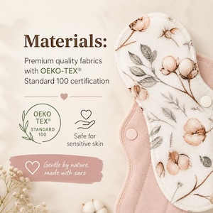 May include: A reusable cloth menstrual pad featuring a cream-colored top layer with a brown and green cotton flower print and a solid dusty pink underside. The pad includes two white snap fasteners and text stating Materials, OEKO-TEX Standard 100.