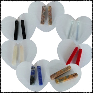 May include: Assortment of eight pairs of gemstone pendant charms. The charms are in various colors, including black, white, red, blue, and brown. Each charm is a rectangular shape with a hole at the top for hanging.