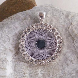 May include: Silver pendant with a round, clear crystal-encrusted frame and a blank center for customization.
