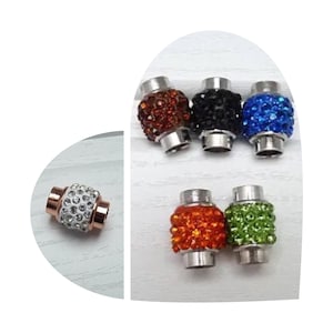 Op de afbeelding: Assortiment van zes magnetische sluitingen voor armbanden of kettingen. De sluitingen zijn zilverkleurig en hebben een rond, facetgeslepen ontwerp met verschillende kleuren strass. De kleuren omvatten helder, oranje, groen, blauw en zwart.
