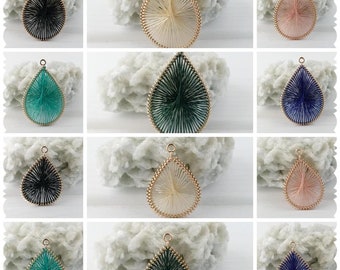 May include: Ten teardrop-shaped pendants with gold-colored metal loops. Each pendant is made of a different color of thread, including black, white, pink, green, blue, and turquoise.
