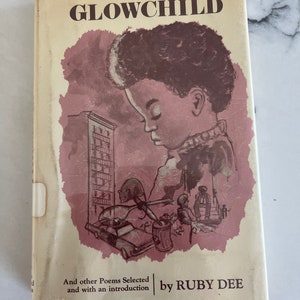 May include: Vintage book titled "GLOWCHILD" by Ruby Dee. The cover features a sepia-toned illustration of a child and a cityscape. The book's title is in a bold, dark brown font, with the author's name at the bottom.