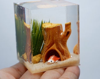 Miniature clay axolotl with log house in the tank