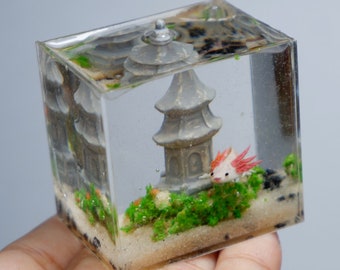 Miniature clay axolotl with little pagoda in the tank
