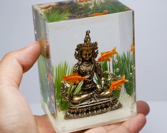 Miniature goldfish with brass statue in the tank