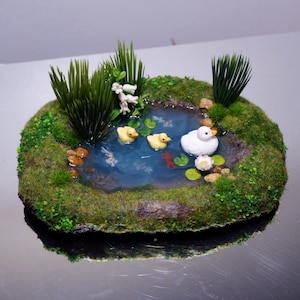 Miniature fish pond with little cute ducks and flowers , fairypond , duck pond