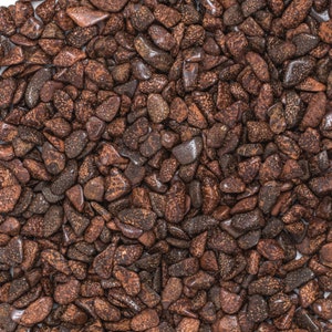 May include: A close-up image of a large collection of small, brown, irregularly shaped stones. The stones have a speckled, mottled appearance.
