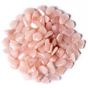 May include: A close-up of a pile of pink rose quartz tumbled stones. The stones are smooth and polished, with a light pink color.