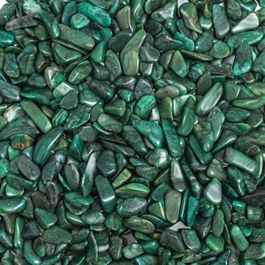 May include: A close-up of a large pile of green aventurine tumbled stones. The stones are smooth and polished, with a variety of shapes and sizes.
