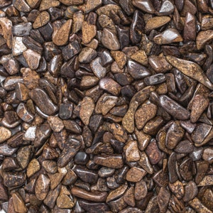 May include: A close-up of a collection of brown and black tumbled stones. The stones are smooth and have a variety of shapes and sizes.