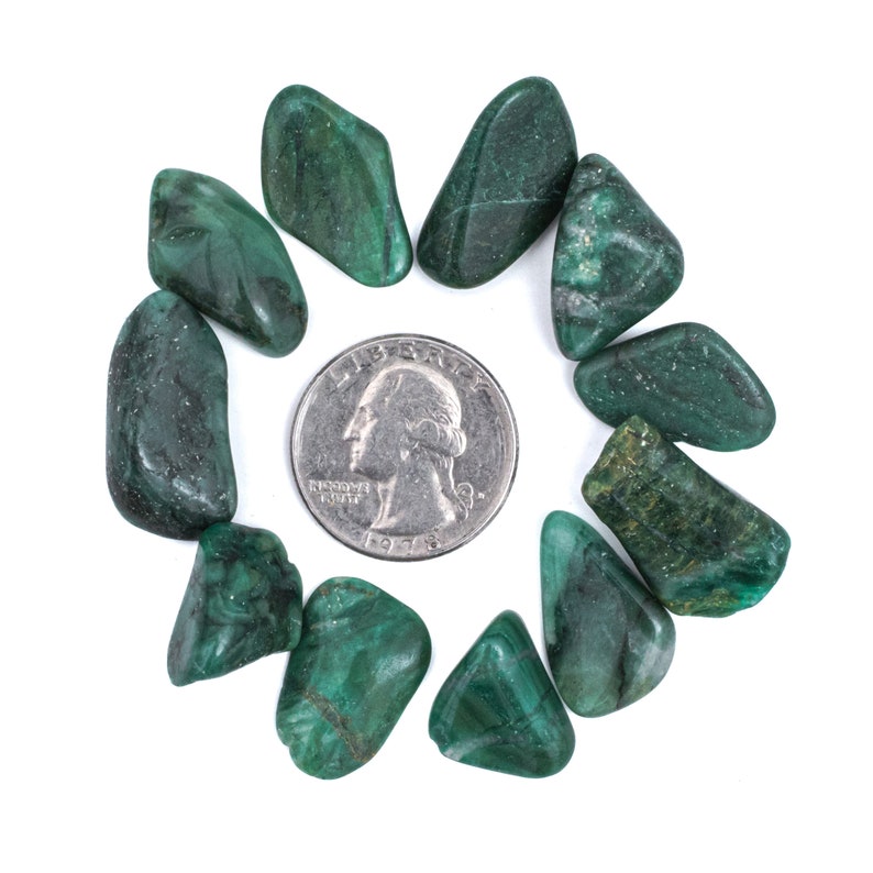 May include: A collection of ten green malachite tumbled stones arranged in a circle around a silver US quarter.