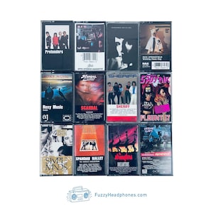 Peut inclure: Une collection de cassettes audio vintage avec des pochettes d'albums de divers artistes. Les cassettes pr&eacute;sentent une vari&eacute;t&eacute; de genres, avec des titres comme "Pretenders", "Roxy Music" et "Spandau Ballet". L'image inclut le site FuzzyHeadphones.com.