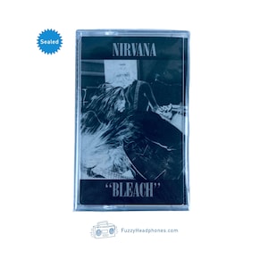 May include: A sealed cassette tape with a black and white photo of a person playing a guitar. The tape is labeled "NIRVANA" and "BLEACH".