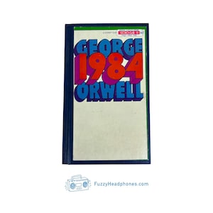 May include: A paperback book titled "1984" by George Orwell. The book cover features the title in large, colorful text: "GEORGE" in blue, "1984" in red, and "ORWELL" in blue. The book has a white background and a dark blue border.