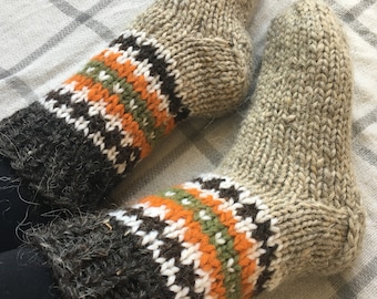 May include: Pair of thick, hand-knitted wool socks with brown, white, orange and green stripes. The socks are made with a fluffy, fuzzy yarn.