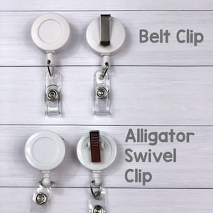 May include: Two white retractable badge holders with different clips. The top holder has a belt clip and the bottom holder has an alligator swivel clip. Both holders have a white plastic reel and a clear plastic strap.