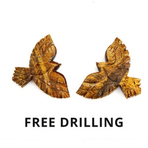 May include: Two carved wooden eagle figurines with outstretched wings, displayed against a white background. The eagles are a warm brown color with detailed feather carvings. The text "FREE DRILLING" is displayed below the eagles.