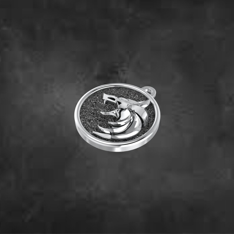May include: A silver pendant with a wolf head emblem in a circular frame. The wolf head is a detailed, three-dimensional design, set against a textured, dark background. The pendant has a small loop for a chain.