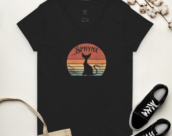 May include: Black v-neck t-shirt featuring a vintage-style graphic of a sphinx cat in front of a sunset. The graphic says "SPHYNX" in a retro font.