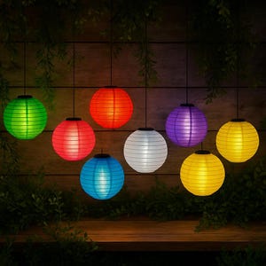 May include: Eight solar-powered paper lanterns hanging from a wooden fence. The lanterns are in various colors, including green, red, purple, white, blue, and yellow.