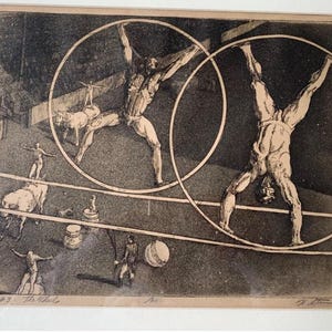 May include: A framed black and white etching depicts a circus scene. Performers balance on tightropes and inside large hoops. The artwork includes text that reads "Circus #3: The Wheels".