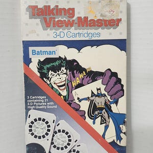 May include: A Talking View-Master 3-D Cartridges box featuring Batman and the Joker. The packaging displays the text Talking View-Master 3-D Cartridges, Batman, and 3 Cartridges containing 21 3-D Pictures with High Quality Sound. The box art shows the Joker holding an ace of spades card with Batman on it.