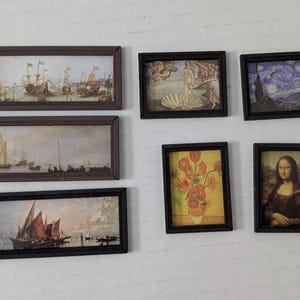 May include: A collection of six miniature framed art prints featuring famous paintings including The Birth of Venus, The Starry Night, Sunflowers, the Mona Lisa, and two maritime scenes with sailing ships, all set in dark brown frames.