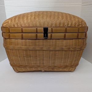 May include: A rectangular woven basket with a domed lid featuring a tight herringbone pattern on top and horizontal weave on the sides. The basket includes a reinforced bamboo frame and a small black metal latch centered on the front edge.