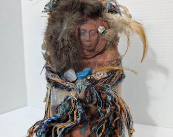 Figura de espírito nativo americano com rosto de argila, feita em técnica mista com tecido, para peso de porta.