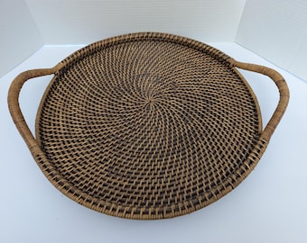 Bandeja grande redonda de vime trançado com base e alças de madeira maciça.