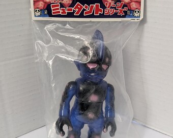 Figura de vinil Sofubi azul transparente da série Mutant Zone, com cabeça machucada, da Real Head, fabricada no Japão. Nova.