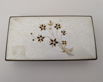 Caixa retangular de metal esmaltado à mão Evans Case Co, com estampa floral preta e detalhes em dourado.