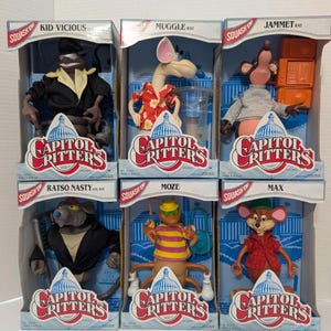 Puede incluir: Seis figuras de acción de Capitol Critters en caja. Los personajes incluyen Kid Vicious, Muggle Rat, Jammet Rat, Ratso Nasty, Moze y Max. Cada figura está en una vitrina de plástico transparente con el logotipo de Capitol Critters.