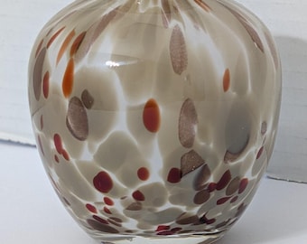Vaso redondo de vidro artístico soprado à mão, creme bege com padrão de manchas em tons de marrom-avermelhado ferrugem.