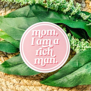 May include: A pink circle sticker with white text that reads "mom, I am a rich man."