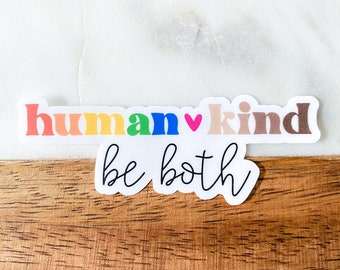 May include: A sticker with the words "human ♥ kind" in rainbow colors and "be both" in black script.