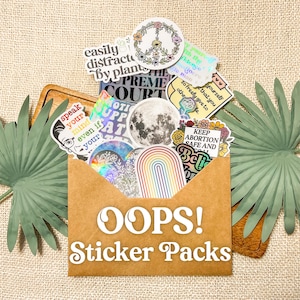 Puede incluir: Un sobre de papel marrón lleno de pegatinas coloridas. Las pegatinas tienen varios diseños y frases, incluyendo "Speak your mind even if you're wrong", "Keep Abortion Safe and Legal", "Easily Distracted by Plants", "Supreme Court" y "Notice Up Sat". El sobre tiene el texto "Oops! Sticker Packs" impreso en él.
