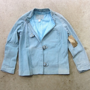 May include: A light blue suede jacket with a zip fastening and three metal buckles. The jacket has a label that says "L.A. Look" on it.