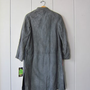 Peut inclure: Un long manteau en daim gris avec un col et une fermeture &agrave; bouton unique. Le manteau porte une &eacute;tiquette "Pellon".