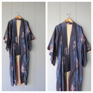 May include: A long, dark blue and pink patterned kimono with a traditional Japanese design. The kimono is made of silk and has a soft, flowing texture.