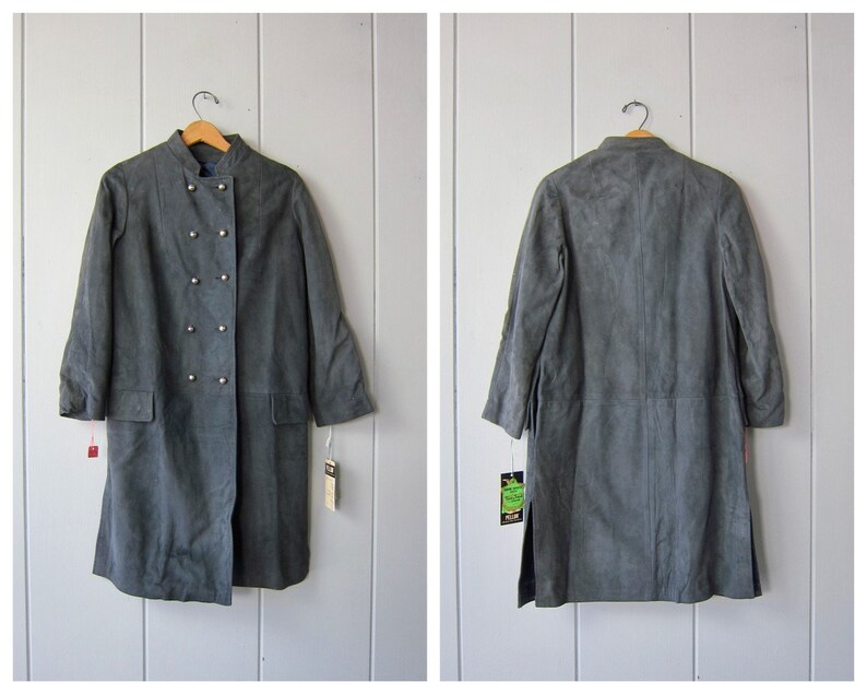 Peut inclure: Un long manteau en daim gris avec une fermeture &agrave; double boutonnage et des d&eacute;tails boutonn&eacute;s. Le manteau a un col mandarin et des manches longues.