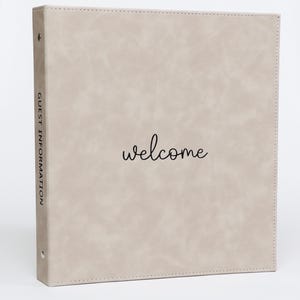 May include: A light beige binder with the word "welcome" in cursive script. The spine reads "GUEST INFORMATION". The binder has a textured appearance and metal rings.