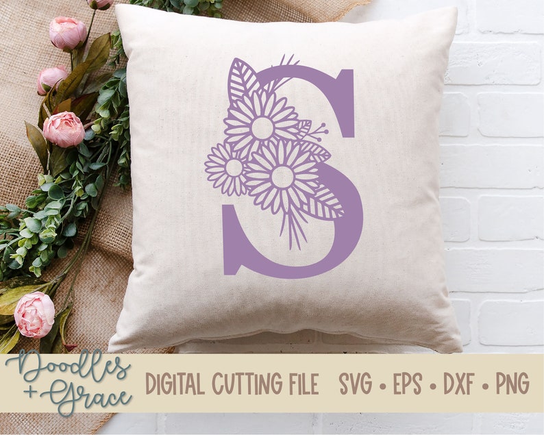 May include: A purple letter S with a floral design. The flowers are stylized and have a delicate, intricate design. The letter is on a white background.