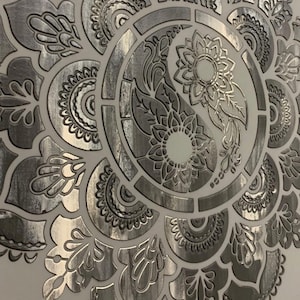 Könnte beinhalten: Ein detailliertes silbernes Mandala-Design mit einem Yin-Yang-Symbol in der Mitte, das florale und geometrische Muster aufweist. Das Design ist auf einem hellen Hintergrund geprägt. Der Text unten lautet "decor for all dfa kiev" und "elf decor ua".