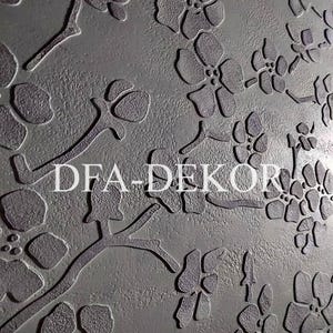 May include: A textured, gray surface with a floral pattern in a darker shade. The design features stylized flowers and branches. The text "DFA-DEKOR" is displayed in white across the center of the image.