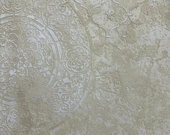 May include: A textured wall surface featuring a light beige finish with a raised, matte plaster effect. The design includes a large circular medallion pattern on the left and a repeating geometric lattice motif on the right, both in relief.