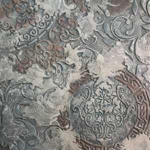 May include: Textured square artwork with a distressed, layered appearance. The piece features a mix of gray, blue, and brown tones with ornate, embossed patterns. The design includes floral and geometric motifs, creating a vintage aesthetic.
