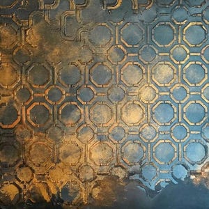 May include: Abstract artwork featuring a repeating geometric pattern of octagons and circles in gold and blue hues. The design has a textured appearance, with areas of darker and lighter tones creating depth. The overall effect is reminiscent of aged metal or a weathered surface.