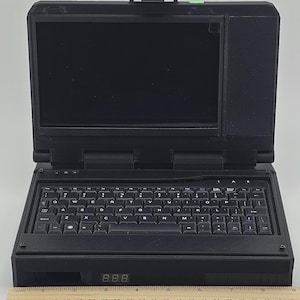 May include: A black laptop computer with a built-in screen and a full keyboard. The laptop has a digital display showing the number 8.88.