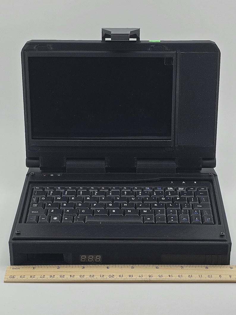 May include: A black laptop computer with a built-in screen and a full keyboard. The laptop has a digital display showing the number 8.88.